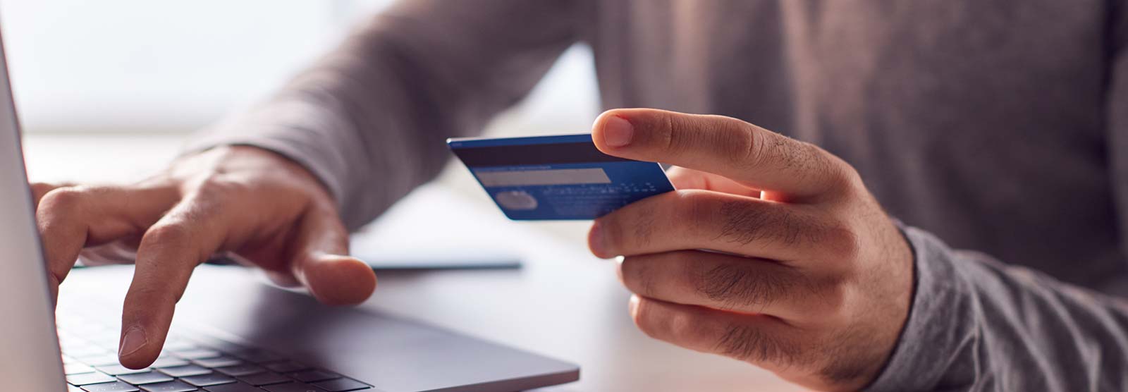 Man using a credit or debit card at a laptop computer